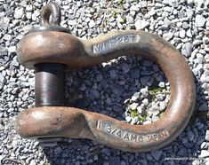 an old rusted chain laying on top of some rocks and gravel with words written on it