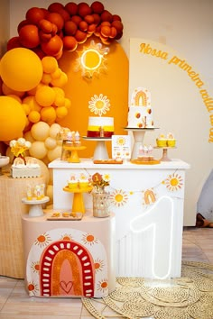 an orange themed birthday party with balloons and desserts on the table, along with other decorations