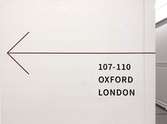 an arrow pointing to the left on a white wall