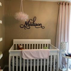 a baby's room with a white crib and pink drapes