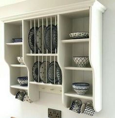 a white shelf filled with plates and bowls