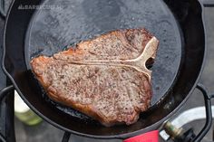 a steak is cooking in a skillet on the grill