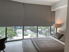 a bedroom with a large window covered in blinds