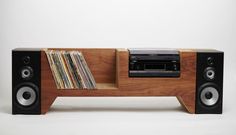 a wooden entertainment center with cd's and cassettes on it, in front of a white background