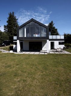 a white house sitting on top of a lush green field