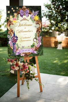 a welcome sign with flowers on it in the middle of a lawn area at a wedding