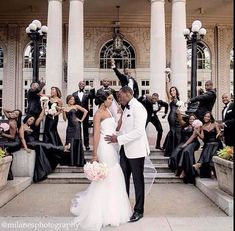 a bride and groom standing in front of a large group of people