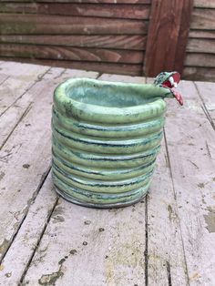 a green planter sitting on top of a wooden table