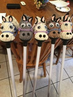 five horse head canes are lined up on the dining room table, ready to be used as decorations