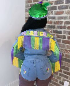 the back of a woman's jean jacket with mardi gras on it