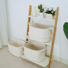 three white baskets sitting on top of a shelf