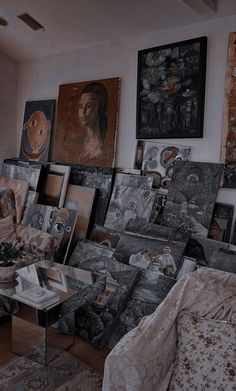 a living room filled with lots of furniture and paintings on the wall next to a window