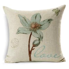 a blue flower on a white pillow with the word love written in cursive writing