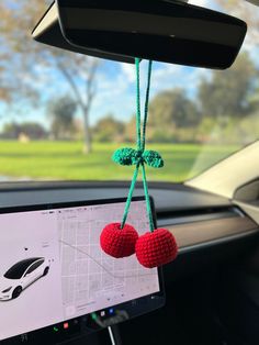 two red balls hanging from the dashboard of a car