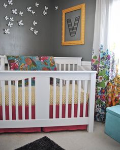 a baby's room decorated in gray, yellow and red with butterflies on the wall