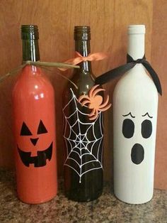 three bottles decorated with halloween decorations on a counter