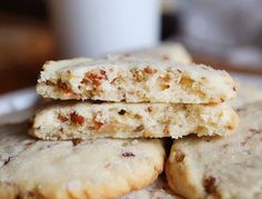 three cookies stacked on top of each other in front of a white cup and saucer