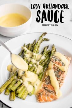 a white plate topped with salmon and asparagus covered in sauce next to a bowl of gravy