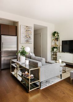 a living room filled with furniture and a flat screen tv on top of a wooden floor