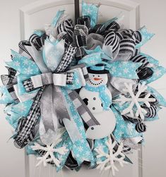 a snowman wreath is hanging on the front door, decorated with ribbons and bows