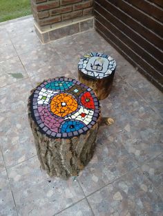 two colorful mosaics are sitting on top of a tree stump