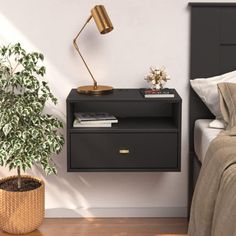 a bedroom with a bed, nightstand and plant on the side table next to it