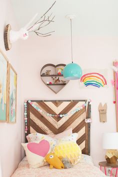 a bedroom decorated in pastel colors with heart shaped decorations on the headboard and bed