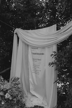 a white sheet draped over some bushes and trees in front of a sign that reads lautrionia