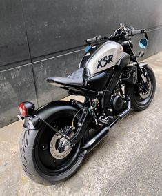 a black and white motorcycle parked next to a building