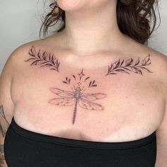 a woman with tattoos on her chest has a dragonfly tattoo on it's chest