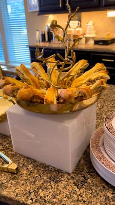 a kitchen counter topped with plates and bowls filled with food next to a plant in a bowl