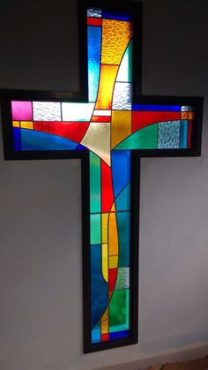 a stained glass cross hanging on the wall