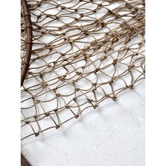 a close up of a fishing net on a white surface with rusted metal handles