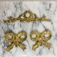 two decorative gold handles on a marble surface