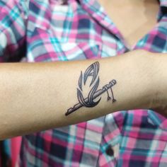 a woman's arm with a tattoo on it that has an image of a bird holding a wrench