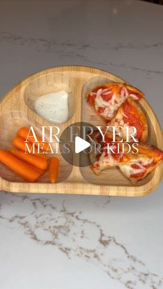 a wooden tray filled with pizza and carrots