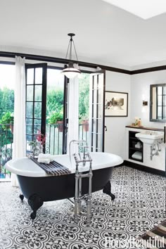 a bathroom with black and white tile flooring and an old fashioned bathtub in the center