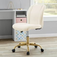 a white office chair sitting on top of a hard wood floor next to a window