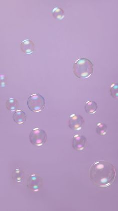 soap bubbles floating in the air on a purple background