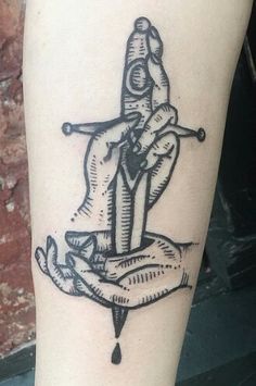 a black and white tattoo on the leg of a person with a knife in their hand