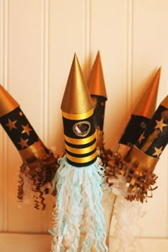 some gold and black party hats are on top of each other in front of a door