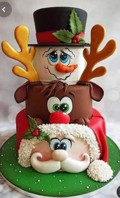 a three tiered cake decorated like a snowman and reindeer