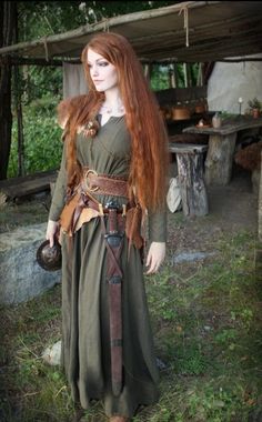 a woman with long red hair wearing a green dress