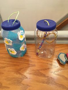 two plastic water bottles sitting on top of a wooden floor next to cookies and candy