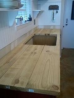 a kitchen counter made out of plywood with a hole in the center for storage