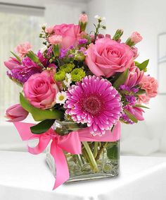 a vase filled with pink flowers on top of a table