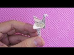 a person holding up a piece of paper with an origami bird on it