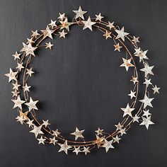 a wreath made out of metal stars on a black background