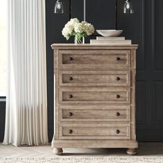 a dresser with flowers on top in a room