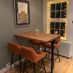 a table with three chairs in front of a window